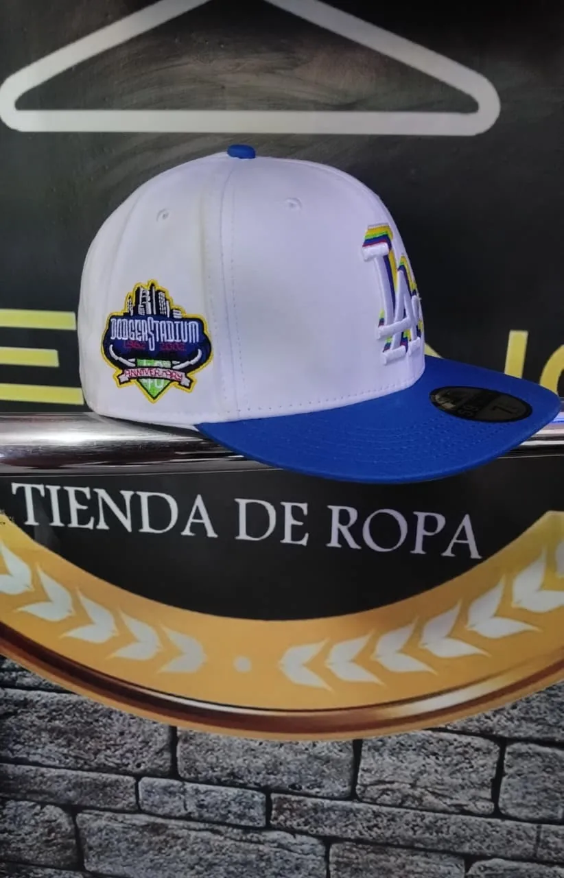 Gorra Dodgers LA blanca y azul, logo arcoíris (perfil, parche Dodger Stadium), disponible en PRESENCIA, Cartagena